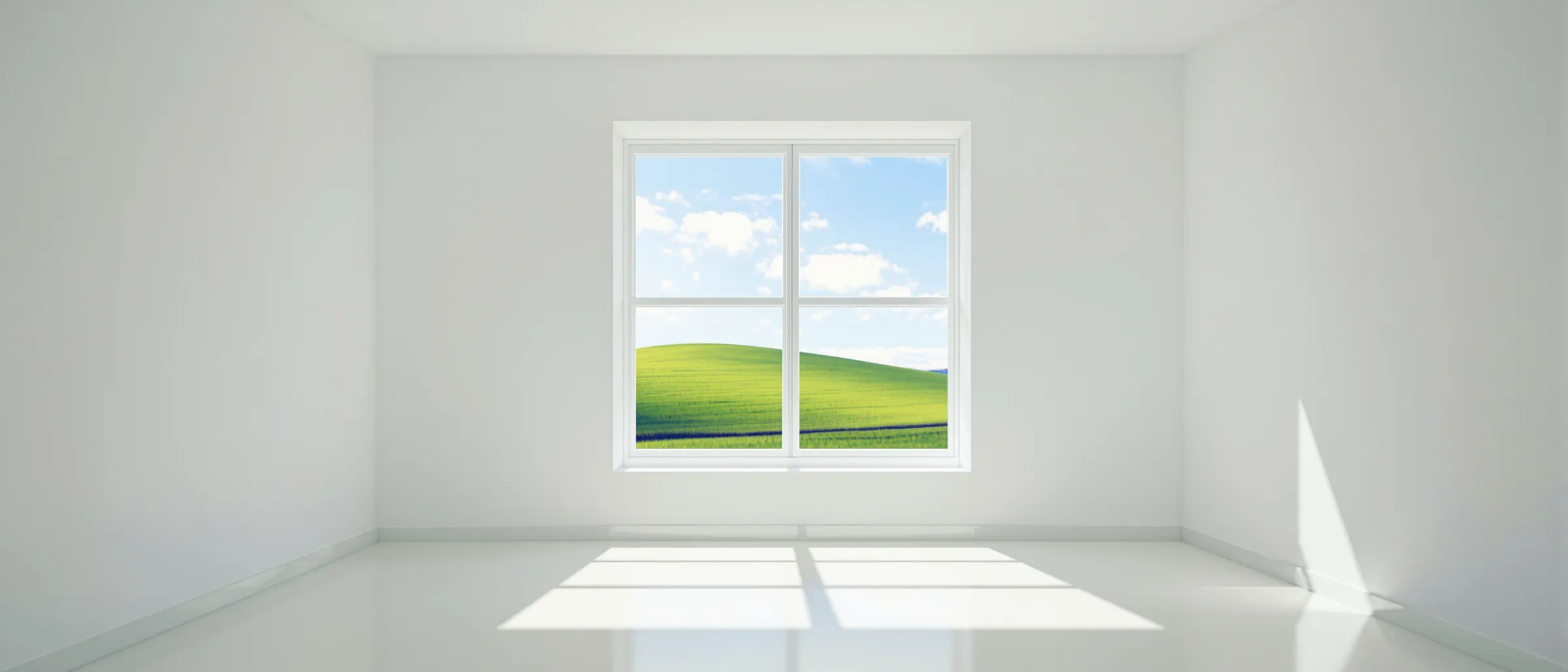 An empty white room with a four-pane window looking out on a green hill and blue sky